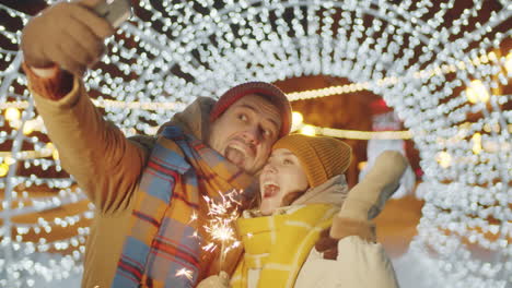 Fröhliches-Paar,-Das-Draußen-Ein-Selfie-Mit-Weihnachtswunderkerze-Macht
